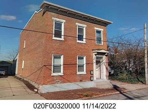 A red brick house with a white door and windows.