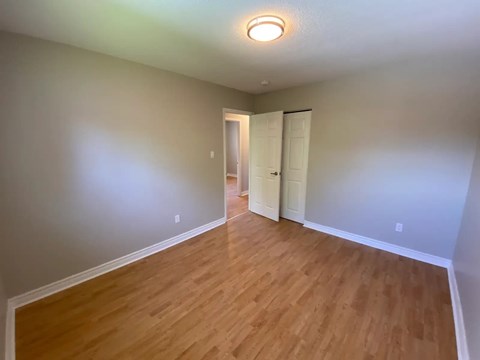 A room with wooden flooring and a white door.
