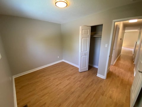 A room with wooden flooring and a white door.