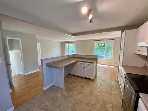 A kitchen with a white fridge, cabinets and a window.