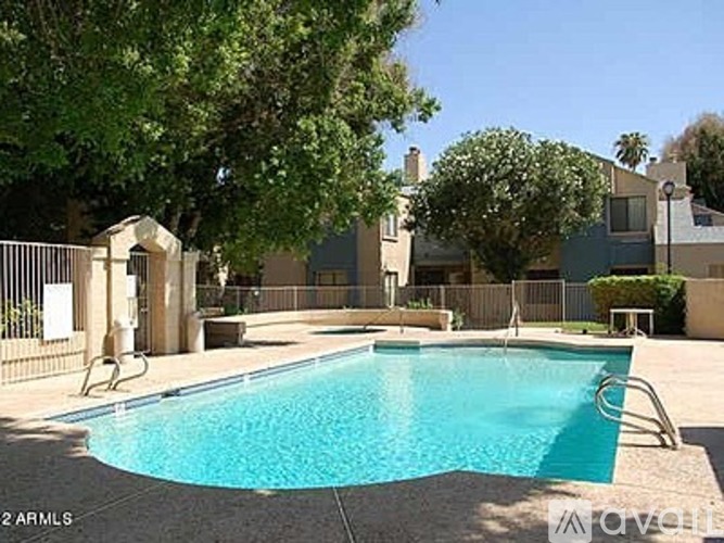 A swimming pool surrounded by a fence and trees.
