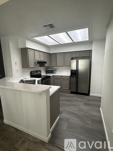 A kitchen with a white counter and a refrigerator.