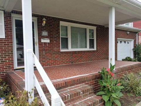 A red brick house with a white door and windows.
