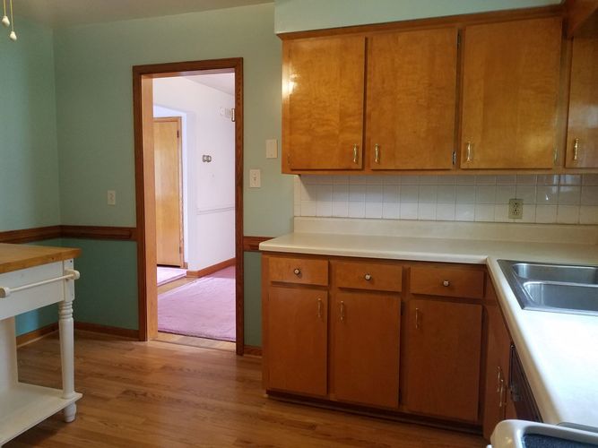 A kitchen with wooden cabinets and a sink.