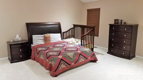 A bedroom with a bed, nightstand, and dresser.
