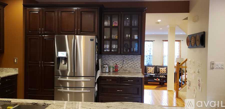 A kitchen with a stainless steel refrigerator and wooden cabinets.