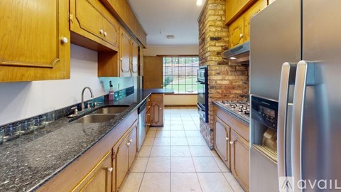 A kitchen with wooden cabinets and a granite countertop.