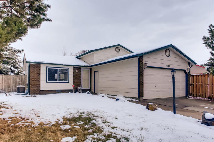 A house with a garage and a driveway covered in snow.