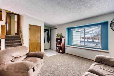 A living room with a tan couch and a blue wall.