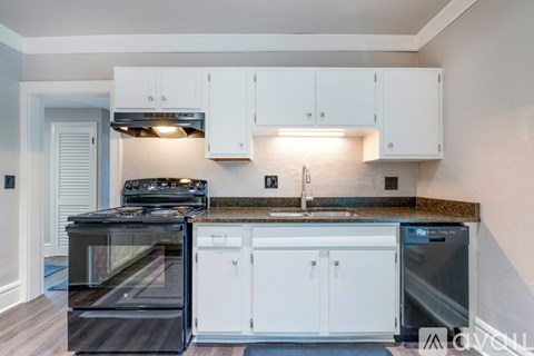 A modern kitchen with white cabinets and a black stove top oven.