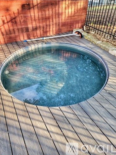 A round above ground pool with a wooden deck.