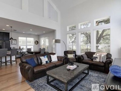A living room with brown leather couches and a glass coffee table.