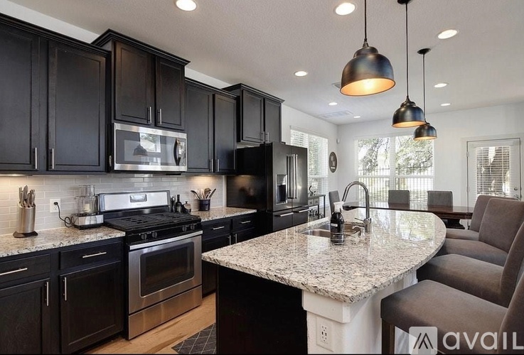 A kitchen with black cabinets and granite countertops.