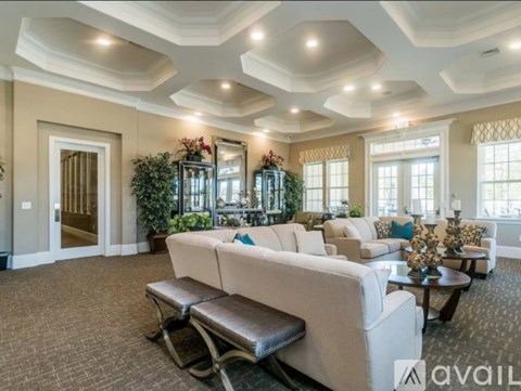 A living room with a white couch and a brown bench.