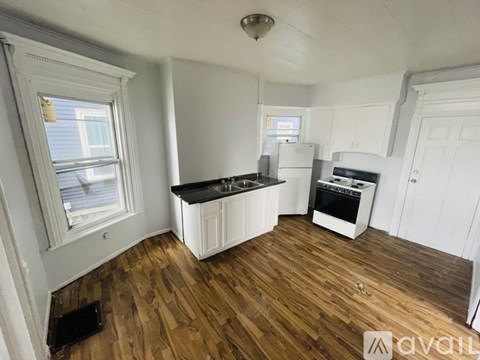 A kitchen with wooden floors and white walls.