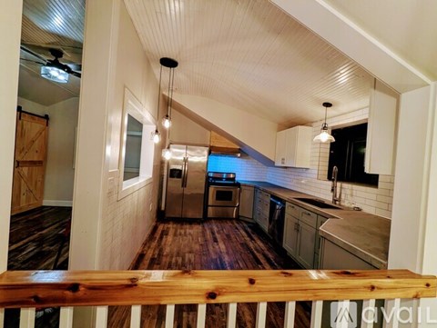 A kitchen with wooden floors and white walls.
