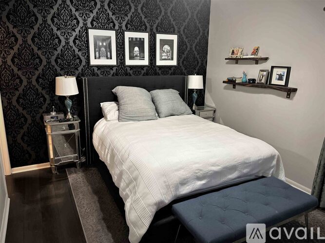 A bedroom with a large bed and a bench in front of it.