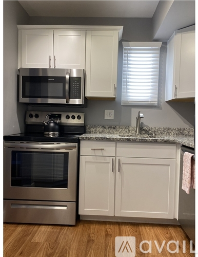 A kitchen with white cabinets and a granite countertop.