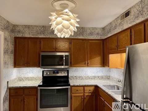 A kitchen with wooden cabinets and a black stove top oven.