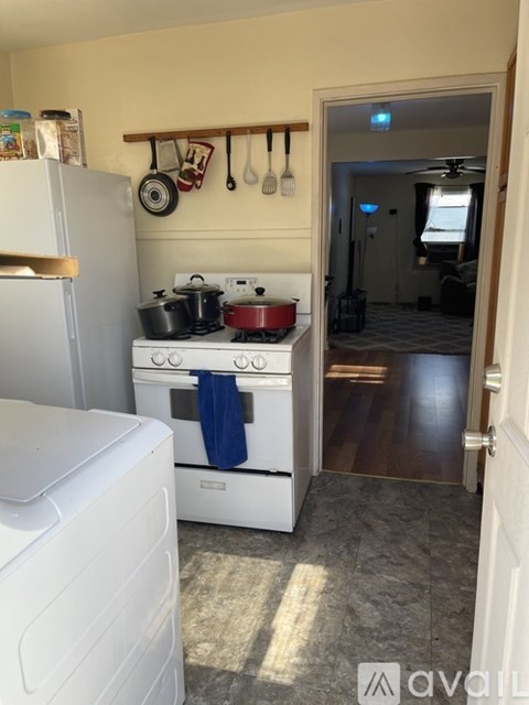 A kitchen with a white stove and a white refrigerator.
