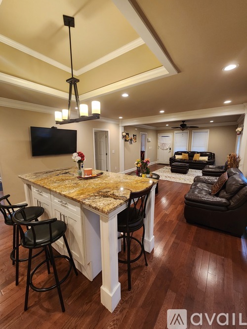 A kitchen with a bar area and a television mounted on the wall.