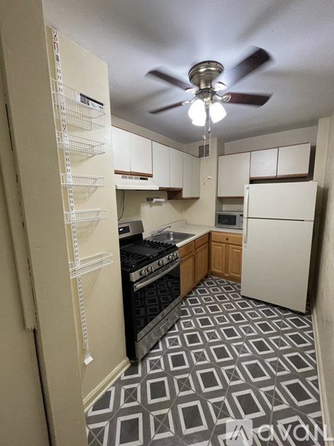 A kitchen with a black stove top oven and a white refrigerator.