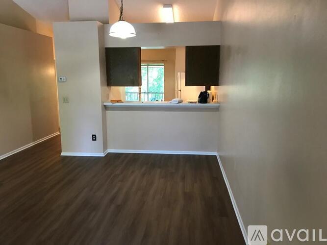 A reception area with a white counter and a hanging light fixture.
