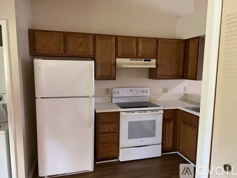 A kitchen with a white refrigerator and white stove.