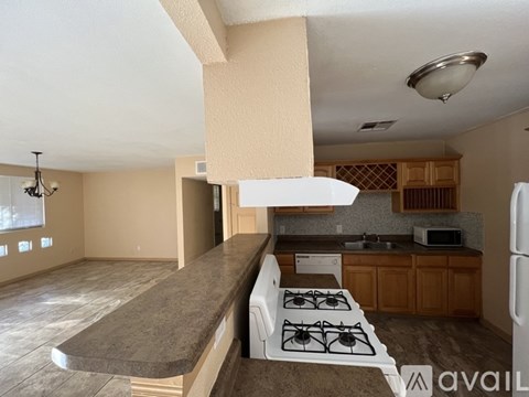 A kitchen with a stove top oven and a refrigerator.