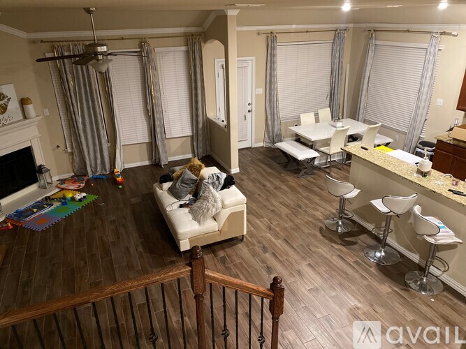 A living room with a couch, a chair, a dining table, and a fireplace.