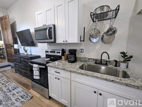 A kitchen with white cabinets and a granite countertop.