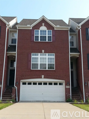 A red brick house with a white garage door.