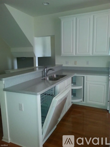 A kitchen with white cabinets and a stainless steel island.