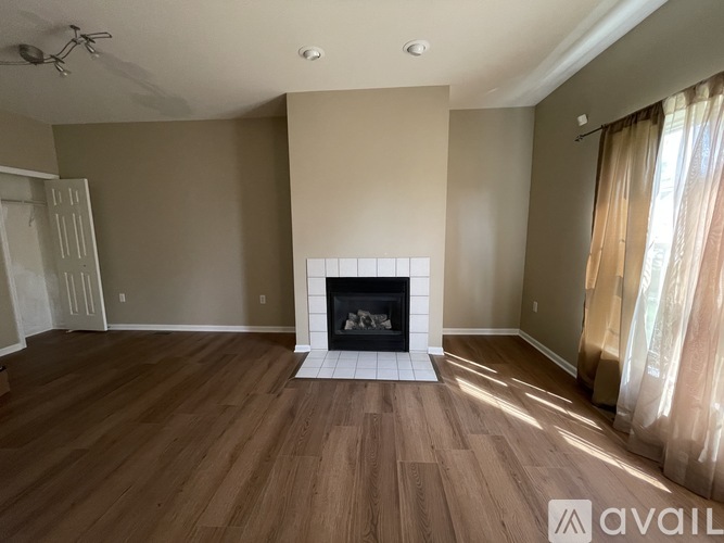 A living room with a fireplace and wood flooring.