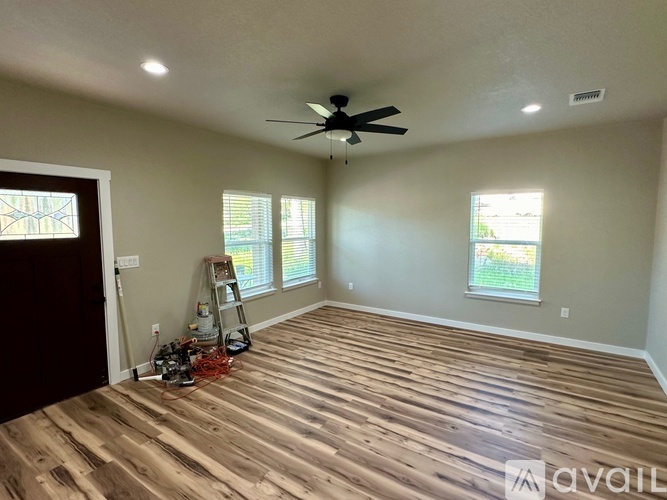 A room with wooden flooring and a ceiling fan.