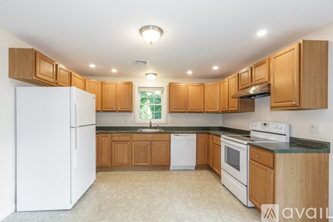 A kitchen with wooden cabinets and white appliances.