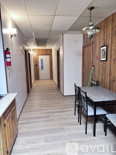 A long hallway with a table and chairs on the right side.