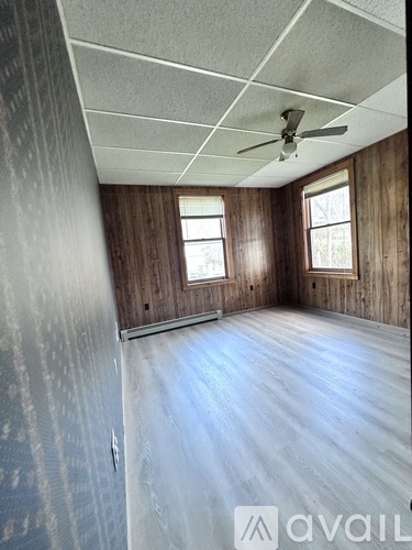 A room with wooden walls and a ceiling fan.