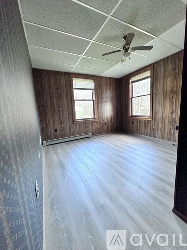 A room with wooden walls and a ceiling fan.