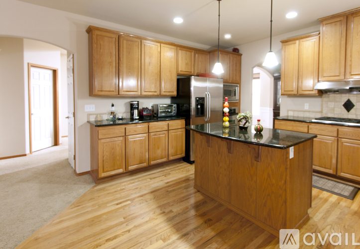 A kitchen with wooden cabinets and a black countertop.
