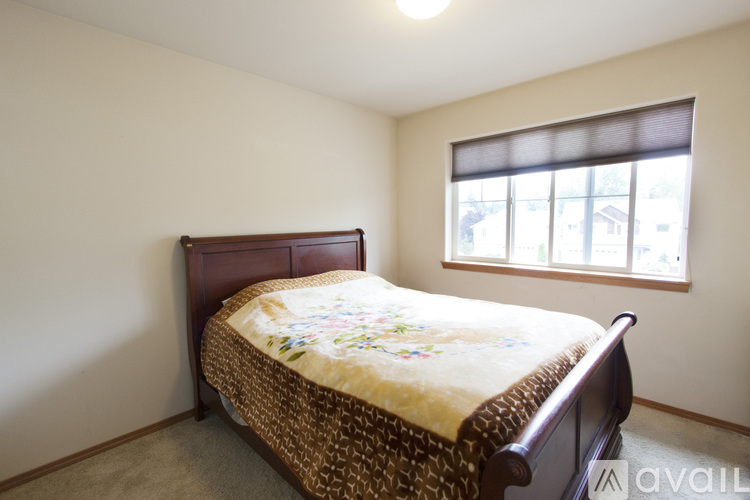 A bedroom with a bed and a window.
