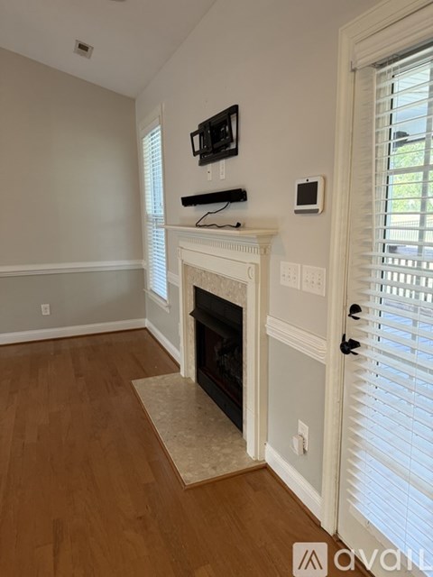 A living room with a fireplace and a flat screen TV mounted above it.