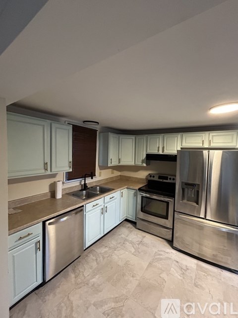 A kitchen with white cabinets and stainless steel appliances.