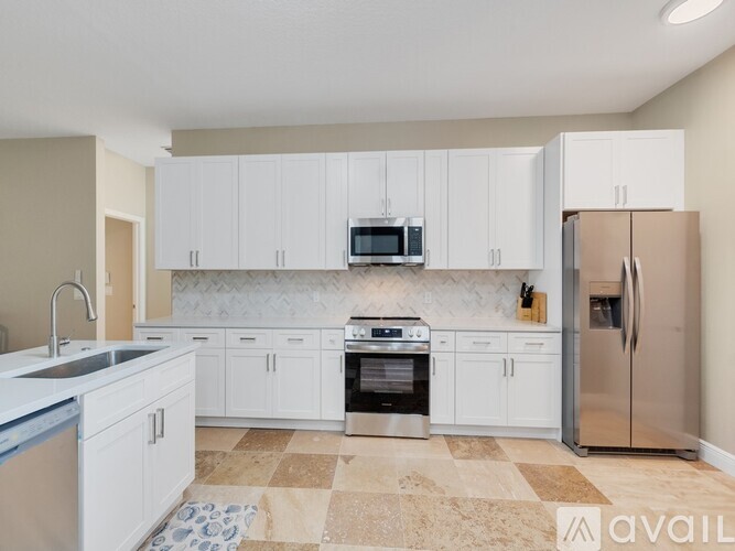 A kitchen with white cabinets and stainless steel appliances.