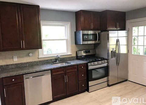 A kitchen with brown cabinets and stainless steel appliances.
