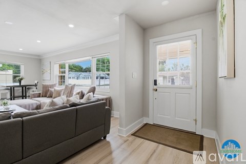 A living room with a grey couch and a white door.