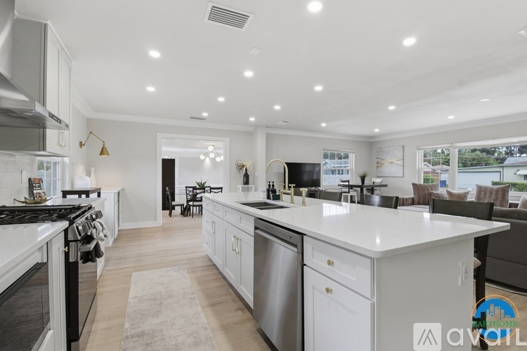 A modern kitchen with white cabinets and stainless steel appliances.
