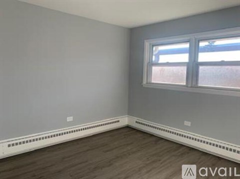 A room with a window and a wall-mounted heater.