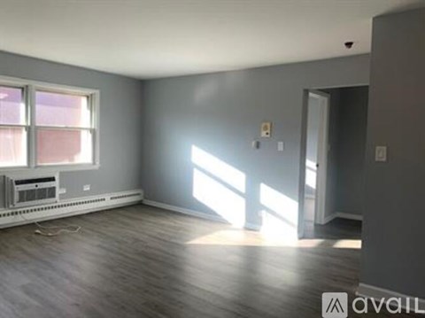 A spacious room with a window and a radiator on the floor.