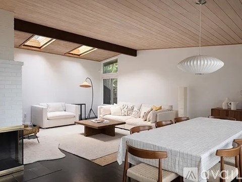 A modern bedroom with a large bed and a fireplace.